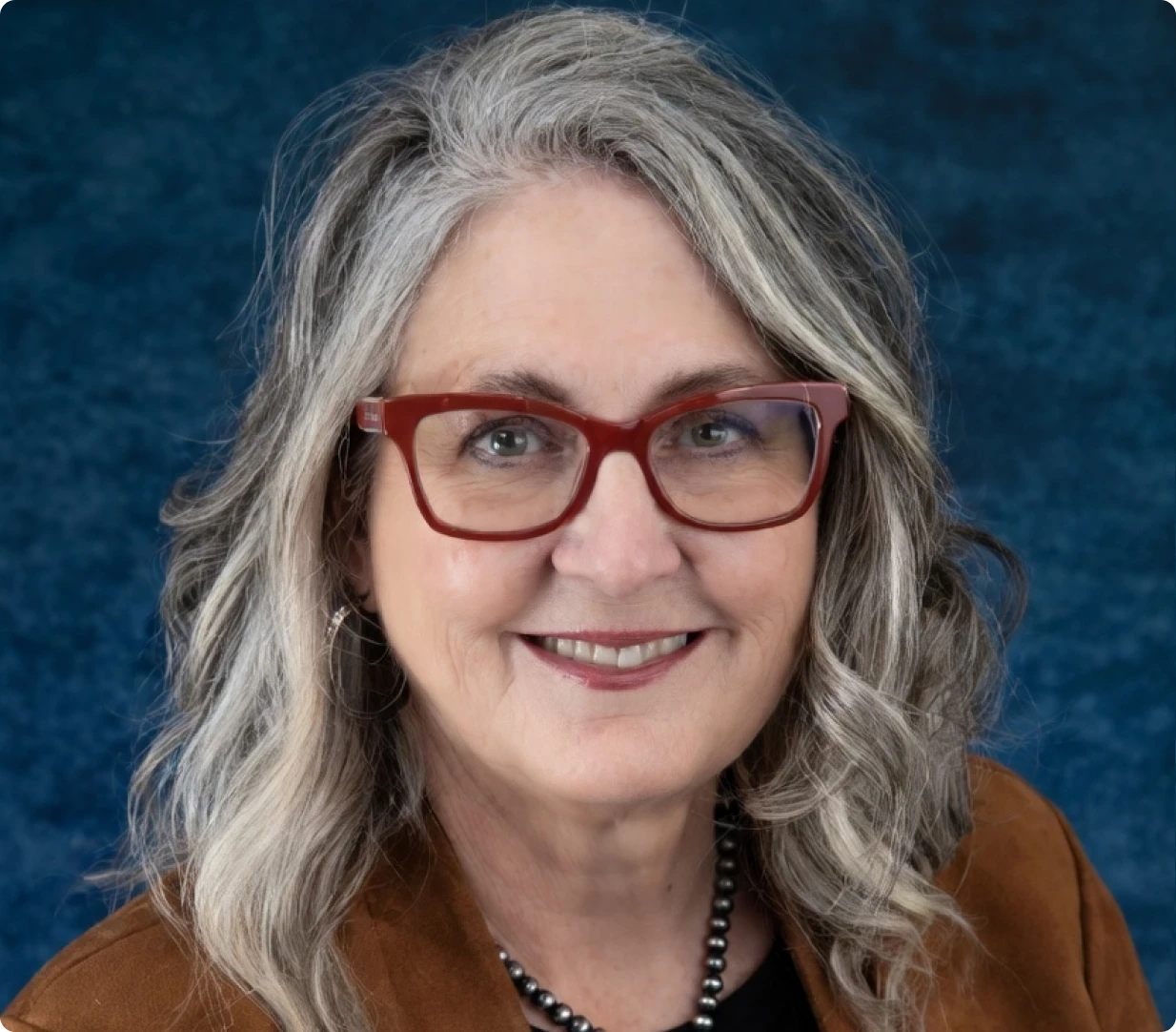 Close-up headshot with red glasses and necklace