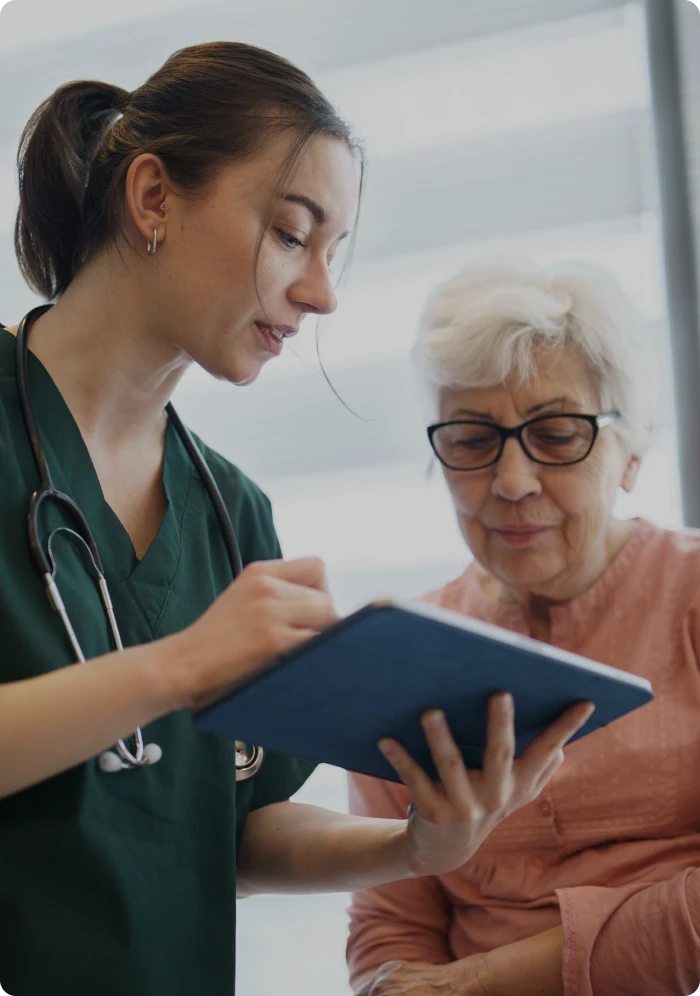Doctor reviewing medical chart with older lady