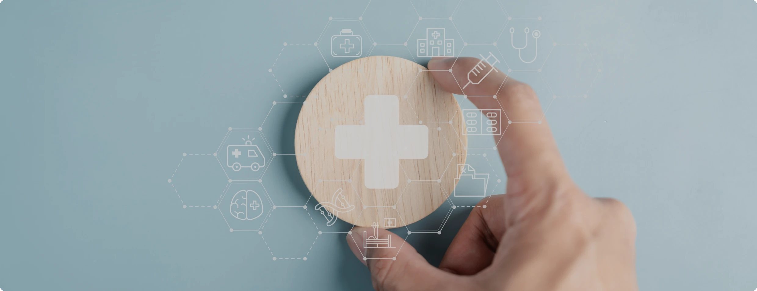 Hand holding wooden circle with medical cross