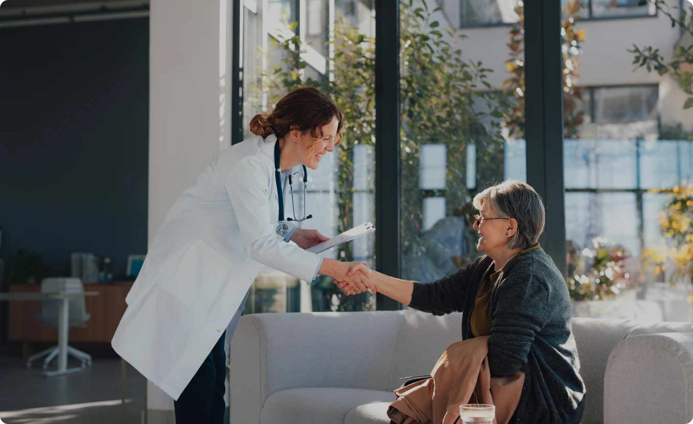 Doctor greeting patient in bright room