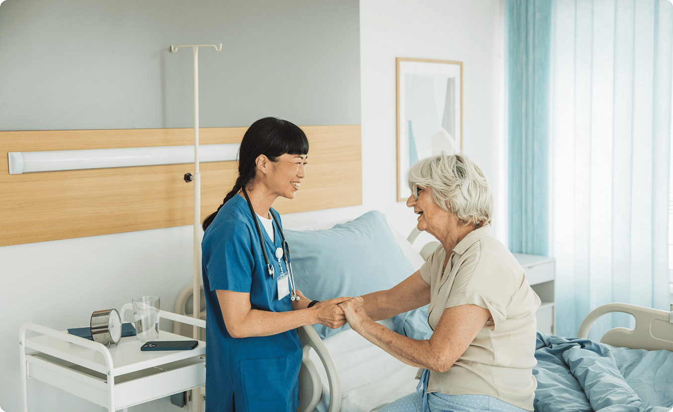 Healthcare professional assisting senior woman in bed