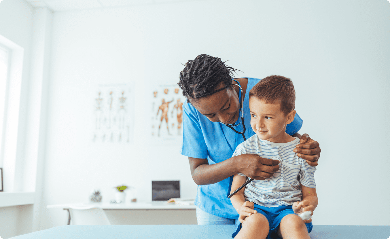 Doctor examining young boy with stethoscope
